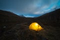 Glowing Yellow Tent and Clouds in Khibiny Mountains at Autumn Night. Russia