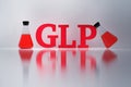 GLP red letters and laboratory flasks reflected on the white surface. Royalty Free Stock Photo