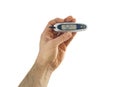 A glucometer in hand with a disposable test strip shows the blood glucose level in units of mg / DL or mmol / l.