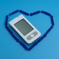 Glucometer inside the heart from sterile lancets isolated on blue background