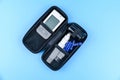 Glucometer isolated on a blue background. Medical device for measuring sugar