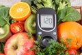 Glucometer for measuring sugar level with fruits and vegetables. Concept of diabetes, healthy lifestyles and nutrition