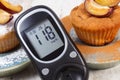 Glucometer, muffins with plums powdered sugar and cinnamon, diabetes and delicious dessert Royalty Free Stock Photo