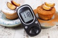 Glucometer, muffins with plums powdered sugar and cinnamon, diabetes and delicious dessert Royalty Free Stock Photo