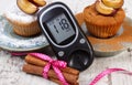 Glucometer, muffins with plums powdered sugar and cinnamon, diabetes and delicious dessert Royalty Free Stock Photo