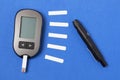 Glucometer with a needle on a blue background. Measurement of blood glucose