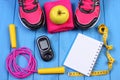 Glucometer, sport shoes, fresh apple and accessories for fitness on blue boards, copy space for text Royalty Free Stock Photo