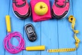 Glucometer, sport shoes, fresh apple and accessories for fitness on blue boards, copy space for text Royalty Free Stock Photo