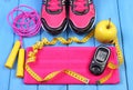 Glucometer, sport shoes, fresh apple and accessories for fitness on blue boards, copy space for text Royalty Free Stock Photo