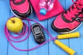 Glucometer, sport shoes, fresh apple and accessories for fitness on blue boards Royalty Free Stock Photo