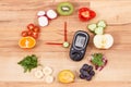 Glucometer with sugar level and fruits with vegetables in shape of clock, healthy breakfast for diabetics concept Royalty Free Stock Photo