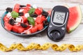 Glucometer with sugar level and summer salad of watermelon and feta cheese. Diabetes, healthy lifestyles and nutrition Royalty Free Stock Photo