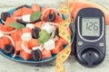 Glucometer with sugar level and summer salad of watermelon and feta cheese. Diabetes, healthy lifestyles and nutrition Royalty Free Stock Photo