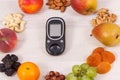 Glucose meter for checking sugar level and food as source minerals, vitamins and fiber, diabetes and healthy nutrition concept