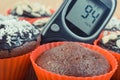Glucose meter for checking sugar level and fresh chocolate muffins. Diabetes and dessert for different occasions