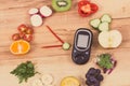 Glucose meter for checking sugar level and fruits with vegetables in shape of clock, healthy food for diabetics concept Royalty Free Stock Photo