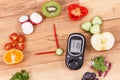 Glucose meter for checking sugar level and fruits with vegetables in shape of clock, healthy food for diabetics concept Royalty Free Stock Photo