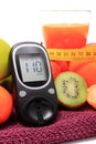 Glucose meter, fruits, tape measure and glass of juice Royalty Free Stock Photo