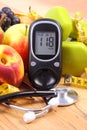 Glucose meter with medical stethoscope, fruits and dumbbells for using in fitness