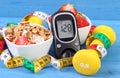 Glucometer with result sugar level, healthy food, dumbbells and centimeter, healthy and sporty lifestyle concept Royalty Free Stock Photo