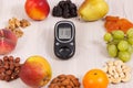 Glucose meter with sugar level and food as source minerals, vitamins and fiber, diabetes and healthy nutrition concept
