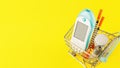 Glucose meter, test strips, syringes in a shopping trolley on yellow background Royalty Free Stock Photo