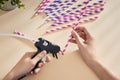 Glue gun in the woman`s hand. Woman glues straws with a glue gun. closeup