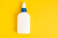 Glue plastic white bottle on a yellow background