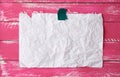 Glued with adhesive tape rectangular empty white crumpled sheet of paper on a pink wooden background Royalty Free Stock Photo