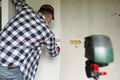 Glueing wallpapers at home. Young man, worker is putting up wallpapers on the wall. Home renovation concept Royalty Free Stock Photo