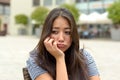 Glum dejected young woman sitting outdoors Royalty Free Stock Photo