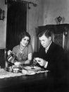 Glum man and adoring woman at breakfast table Royalty Free Stock Photo