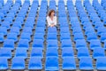 Glum woman sitting in spectator seating