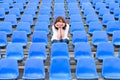 Glum woman sitting in spectator seating