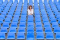 Glum woman sitting in spectator seating