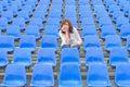 Glum woman sitting in spectator seating