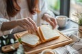 Gluten allergy, woman hand holding bread slice, looking at bread slice at home. Gluten intolerant