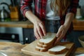 Gluten allergy, woman hand holding bread slice, looking at bread slice at home. Gluten intolerant