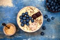 Gluten free amaranth and quinoa porridge breakfast bowl with blueberries and chocolate over rustic wooden background.