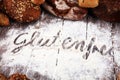 Gluten free breads, glutenfree word written and bread rolls on wooden background Royalty Free Stock Photo