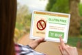 Gluten free diet concept, girl holds the digital tablet on blurred nature background Royalty Free Stock Photo