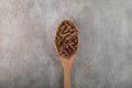 Gluten free flax pasta in wooden spoon on grey background, top view. Uncooked Fusilli made of flaxseed flour. Low glycemic index