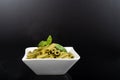 Gluten-free fresh cooked penne pasta from green peas isolated on black background, basil leaf top Royalty Free Stock Photo