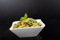 Gluten-free fresh cooked penne pasta from green peas isolated on black background, basil leaf top Royalty Free Stock Photo