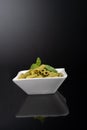 Gluten-free fresh cooked penne pasta from green peas isolated on black background, basil leaf top Royalty Free Stock Photo