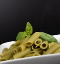 Gluten-free fresh cooked penne pasta from green peas isolated on black background, basil leaf top Royalty Free Stock Photo