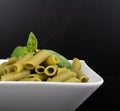 Gluten-free fresh cooked penne pasta from green peas isolated on black background, basil leaf top Royalty Free Stock Photo