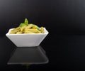 Gluten-free fresh cooked penne pasta from green peas isolated on black background, basil leaf top Royalty Free Stock Photo