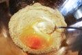 Gluten free low carb cooking - An egg broken into a pile of almond flour with a spoon ready to stir it up in a stainless steal bow