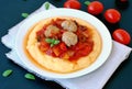 Gluten free meal from meatballs, vegetable ragout and polenta with tomato and basil on white plate on black background Royalty Free Stock Photo